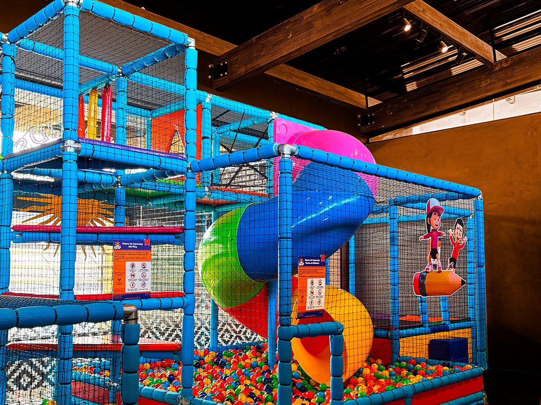 Espaço kids do Campo & Vinho, com piscina de bolinhas, escorregadores e redes de proteção